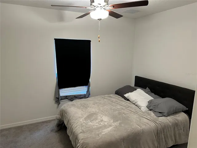 a bedroom with a bed and a ceiling fan