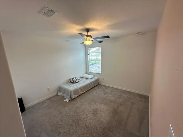 an empty room with a window and a ceiling fan