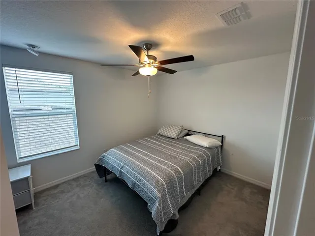 a bedroom with bed and a ceiling fan