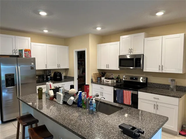 a kitchen with sink a stove and cabinets