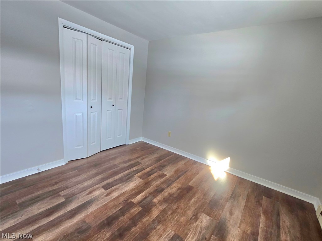 909 Garden Road Zanesville, OH 43701 - Photo 6 of 8 Unfurnished bedroom with dark wood-type flooring and a closet