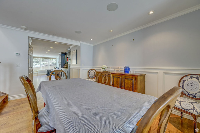 9699 Bypass Road, Unit 5 Alta, UT 84092 - Photo 21 of 54 Dining area featuring wood-finish flooring, crown molding, recessed lighting, wainscoting, and an open entryway