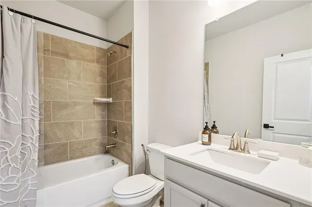 a bathroom with a sink a toilet a mirror a bathtub and shower