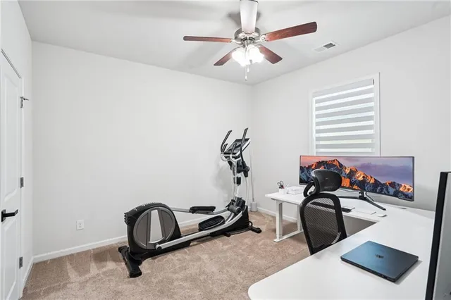 a room with gym equipment and view of living room