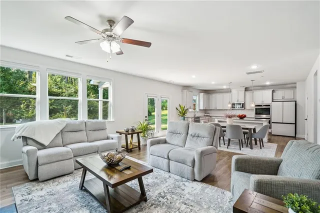 a living room with furniture and view of kitchen