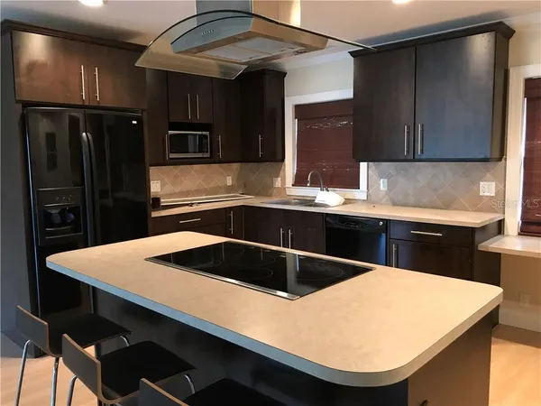 a kitchen with a sink a refrigerator and cabinets