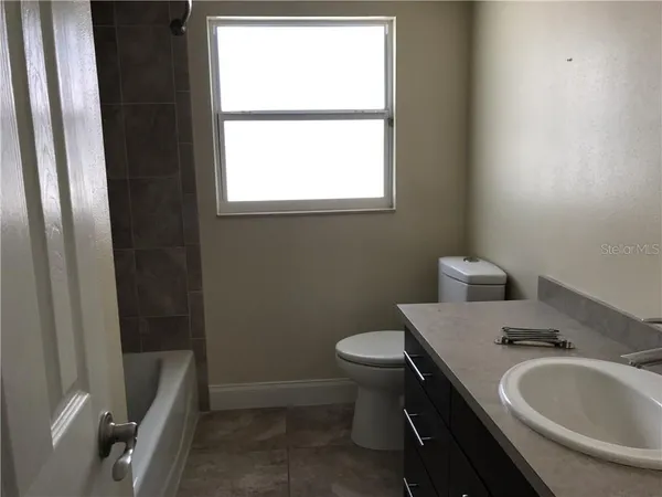 a bathroom with a sink a toilet and tub