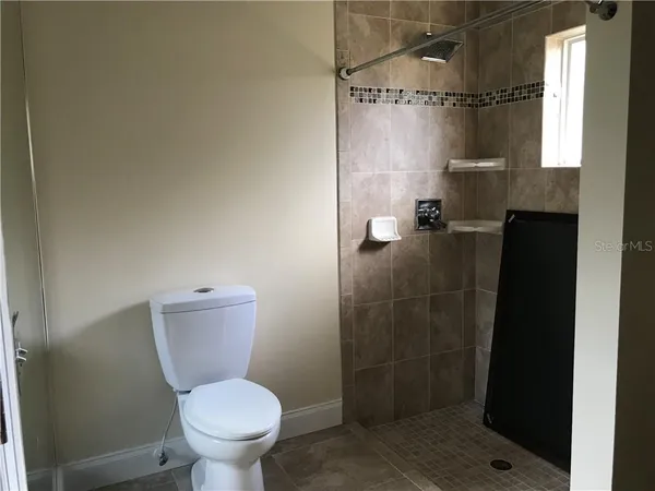 a bathroom with a toilet and a shower
