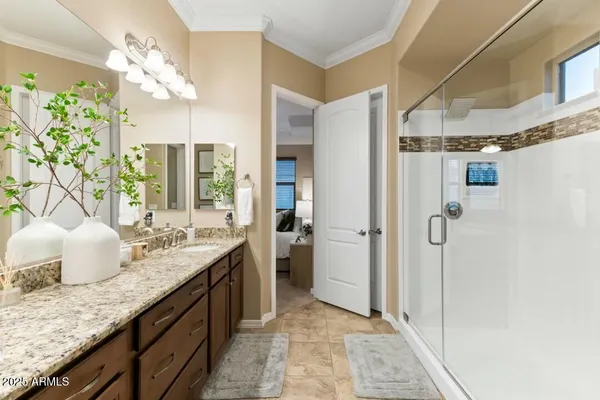 a bathroom with a granite countertop sink a mirror and shower