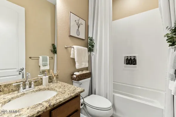 a bathroom with a granite countertop sink a toilet and shower