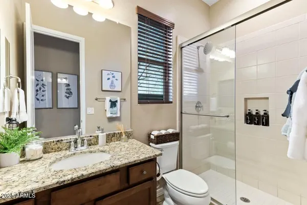 a bathroom with a granite countertop sink mirror vanity and toilet
