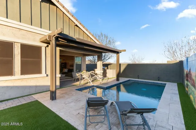 a view of a chair and table in backyard of the house