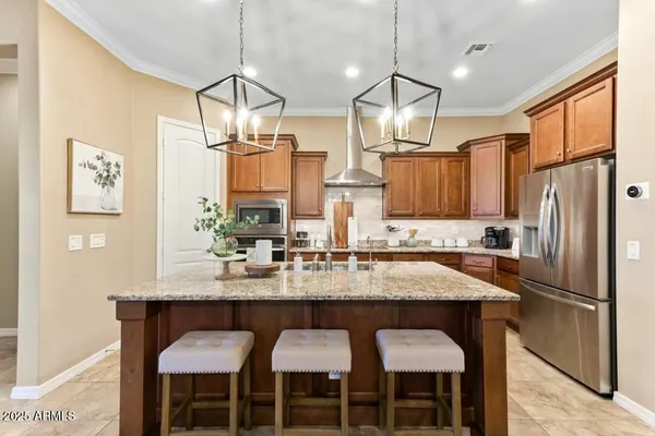 a kitchen with granite countertop a table chairs stove and refrigerator