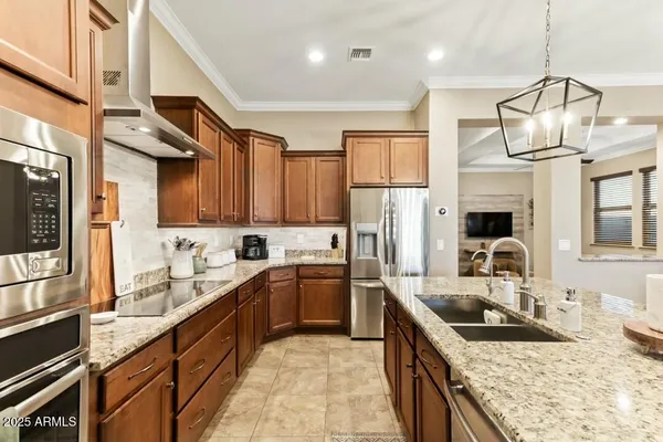 a kitchen with stainless steel appliances granite countertop a sink a stove and a refrigerator
