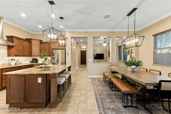 a kitchen with stainless steel appliances granite countertop a stove kitchen island a table and chairs