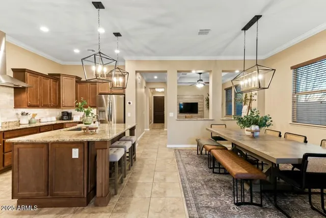 a kitchen with stainless steel appliances granite countertop a stove kitchen island a table and chairs