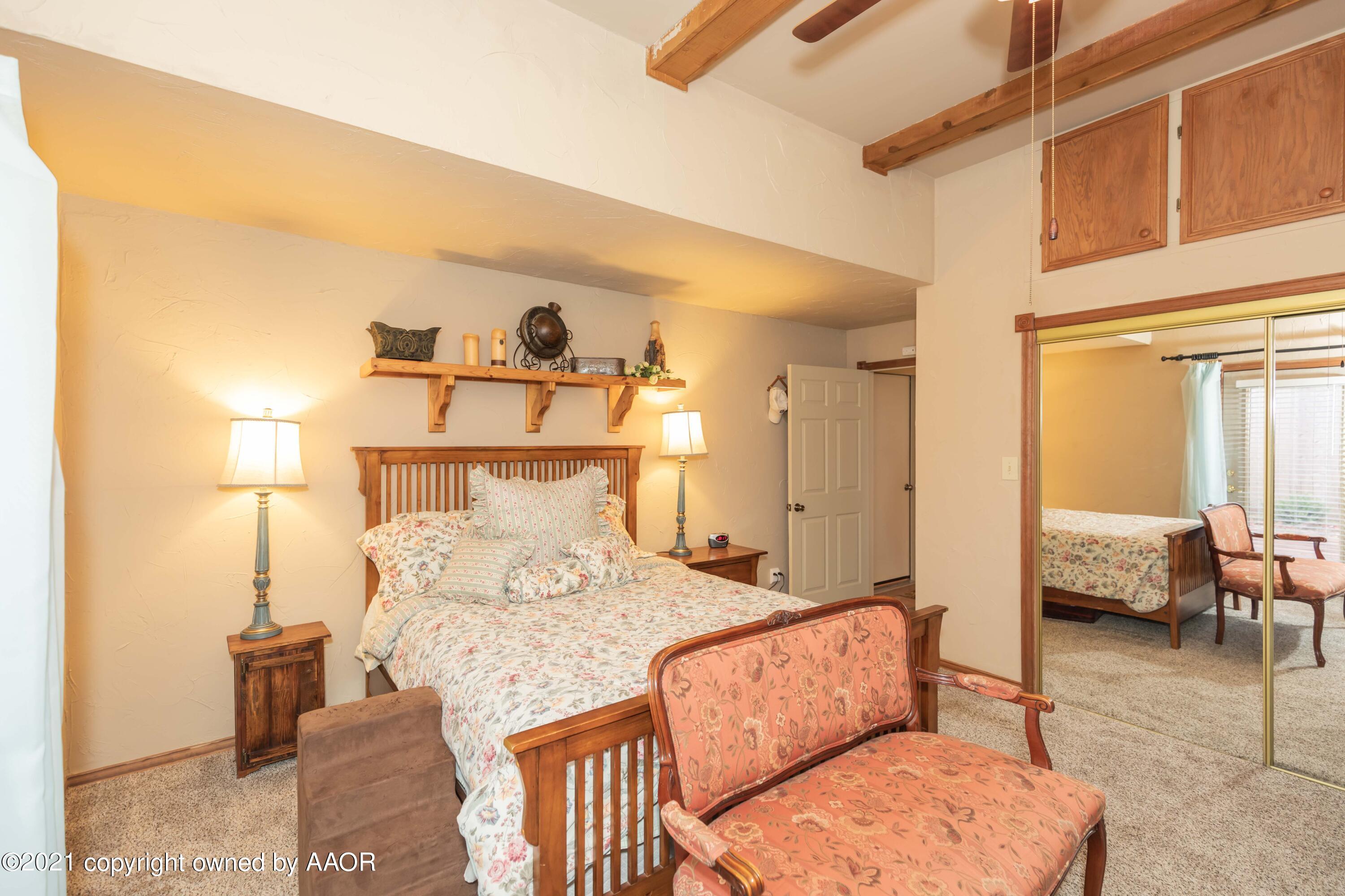 808 Craft Center Road Amarillo, TX 79118 - Photo 27 of 77 a bedroom with a bed a mirror and couch