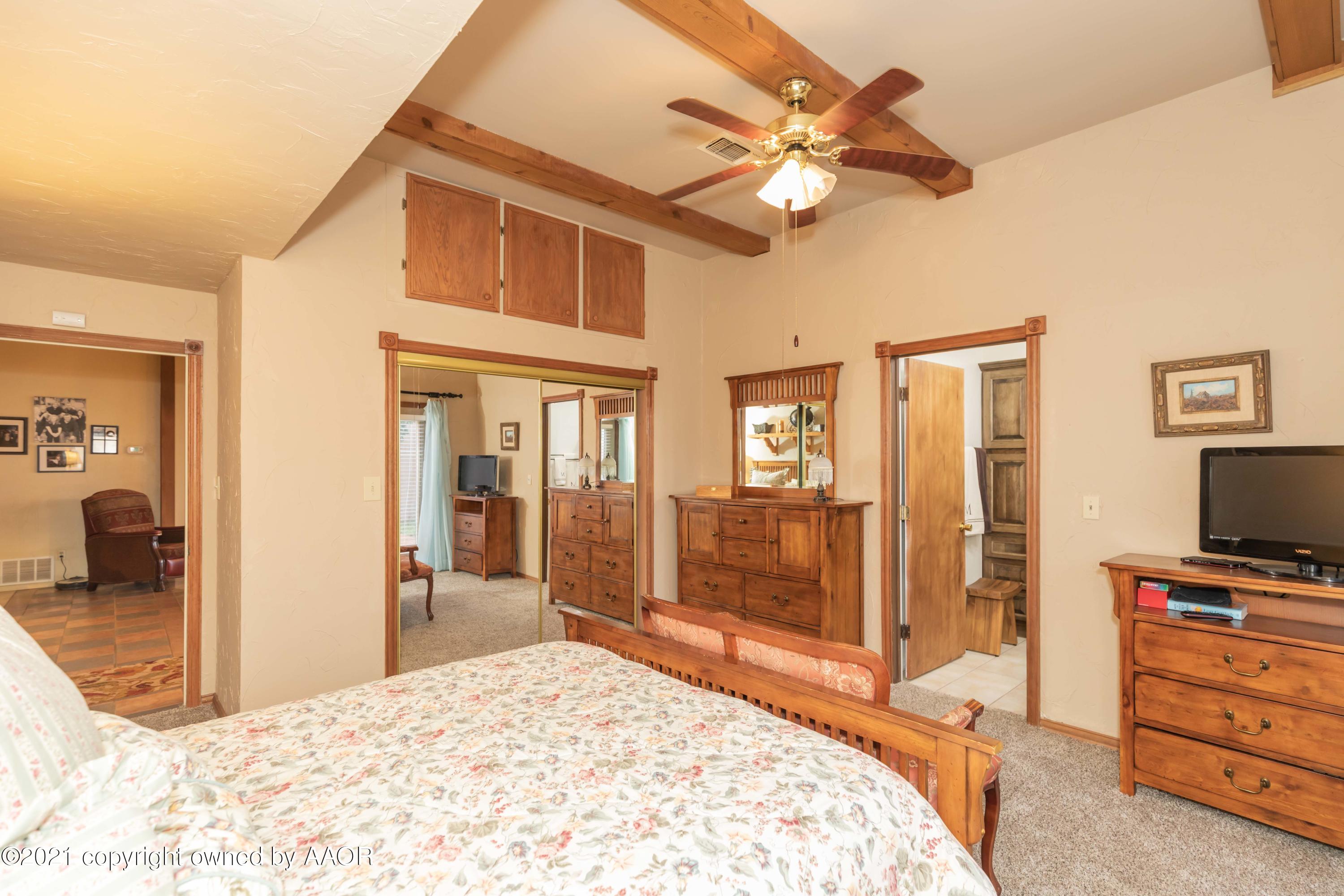 808 Craft Center Road Amarillo, TX 79118 - Photo 29 of 77 a bedroom with a bed and a flat tv screen on dresser