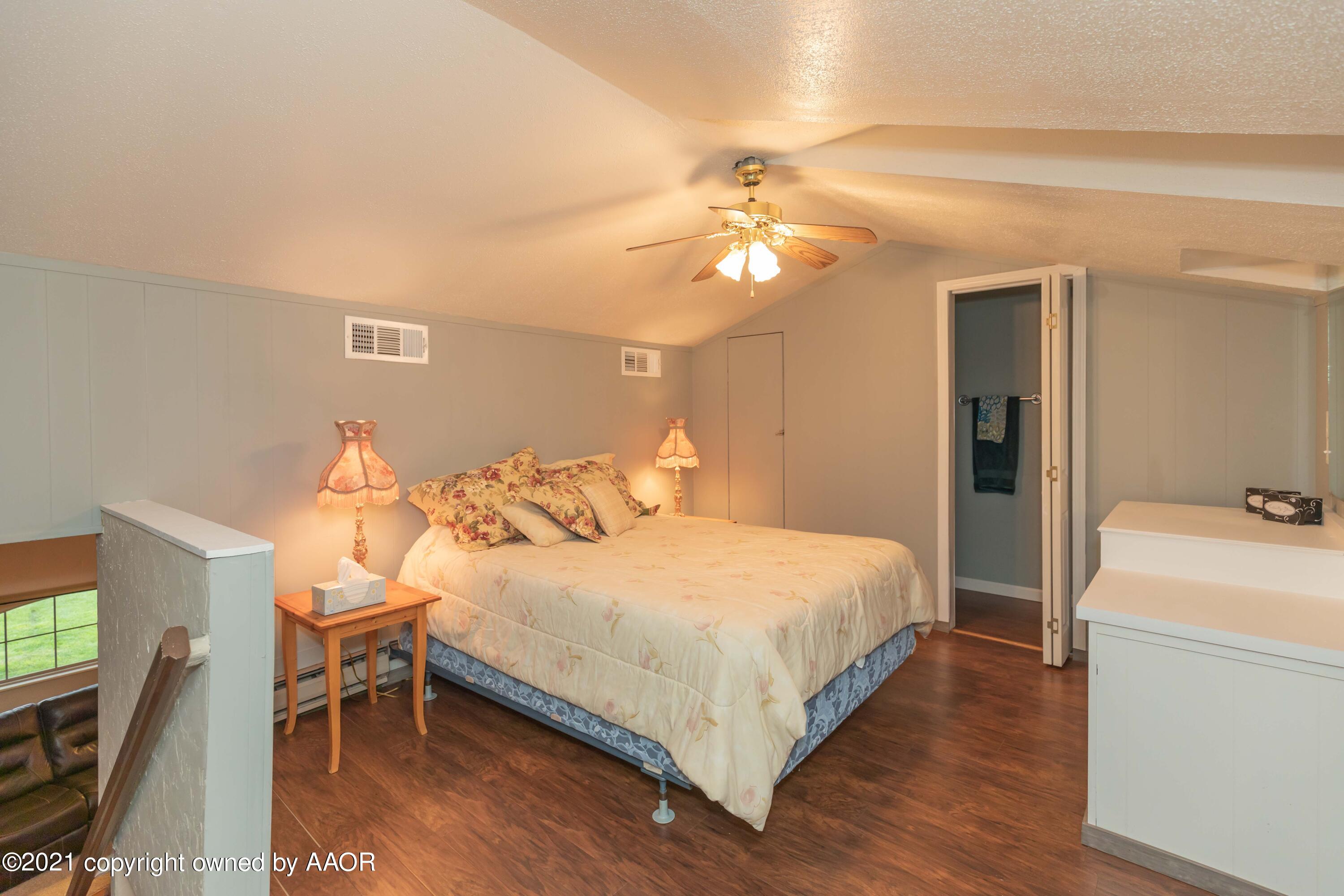 808 Craft Center Road Amarillo, TX 79118 - Photo 41 of 77 a bedroom with a bed and a chandelier