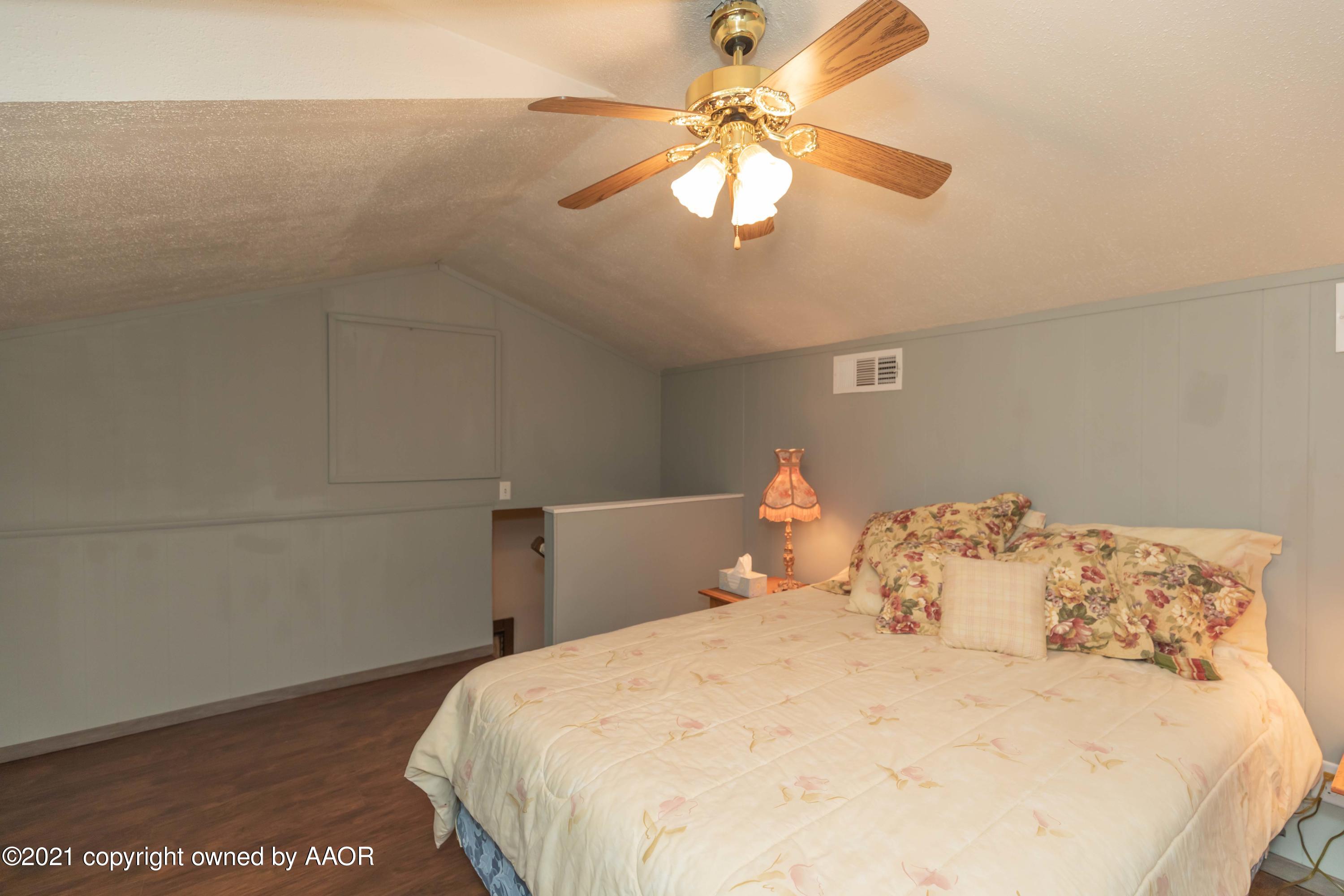 808 Craft Center Road Amarillo, TX 79118 - Photo 42 of 77 a bedroom with a bed and a chandelier