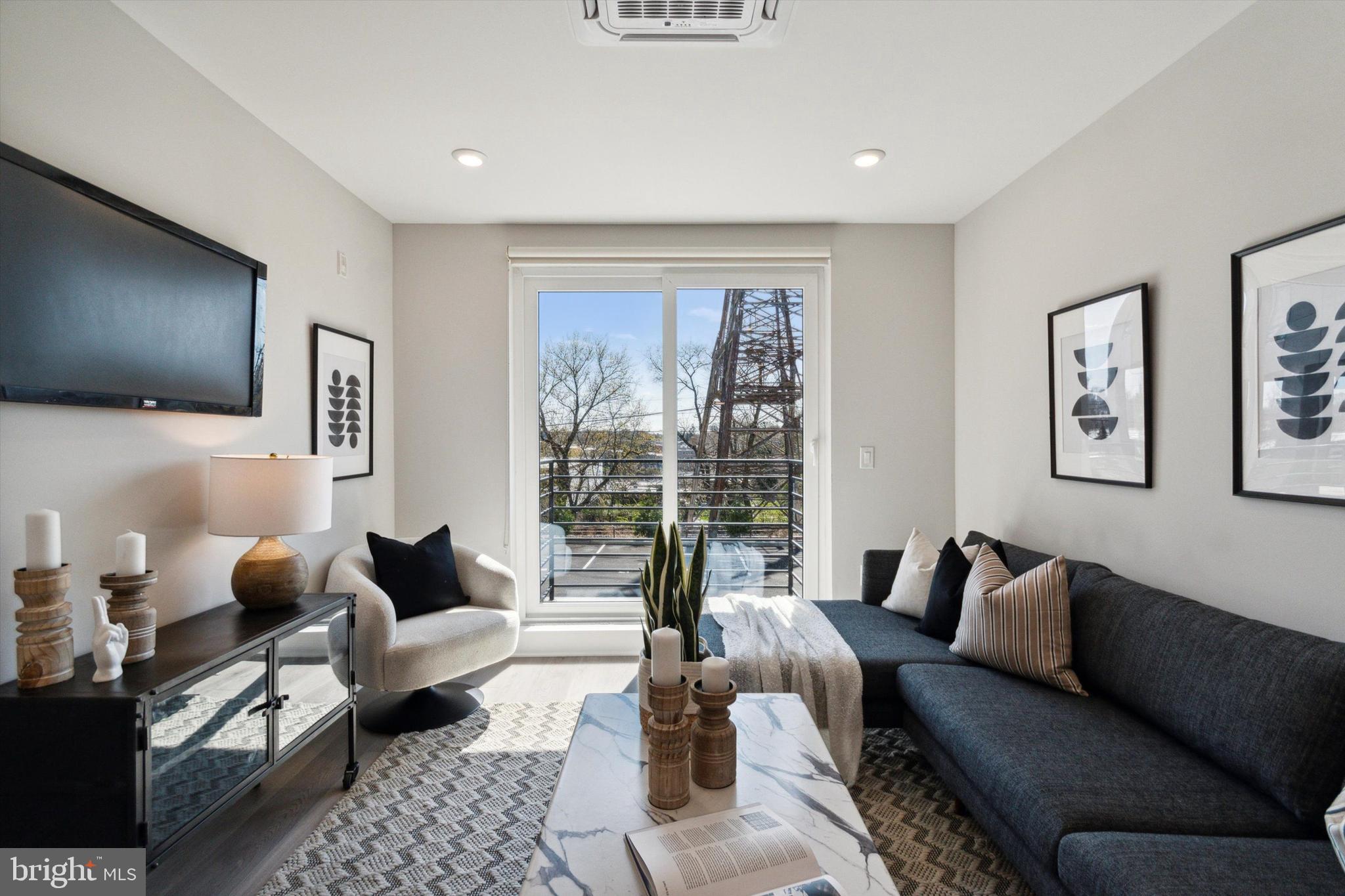 3449 Scotts Lane, Unit A202 Philadelphia, PA 19129 - Photo 2 of 14 a living room with furniture and a flat screen tv