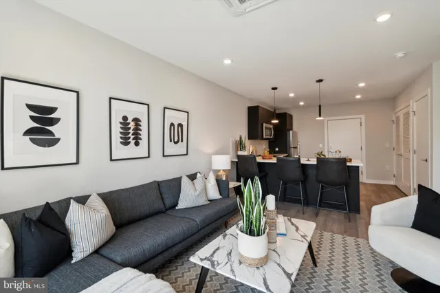 a living room with furniture kitchen view and a table