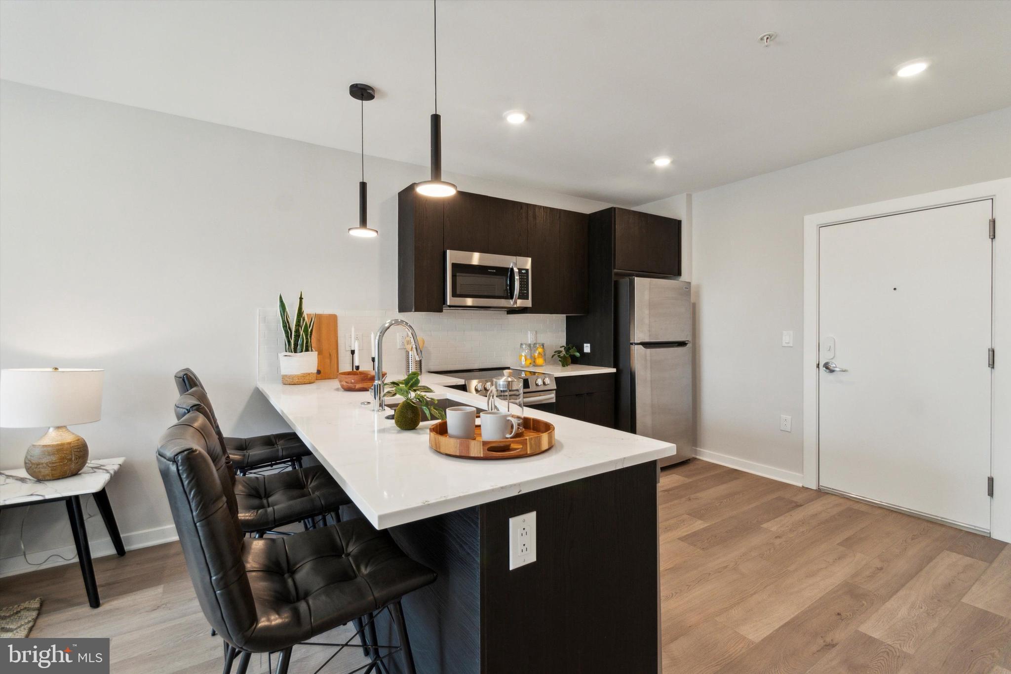 3449 Scotts Lane, Unit A202 Philadelphia, PA 19129 - Photo 5 of 14 a open kitchen with a dining table and chairs