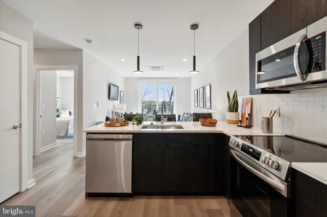 a kitchen with stainless steel appliances a sink stove and cabinets