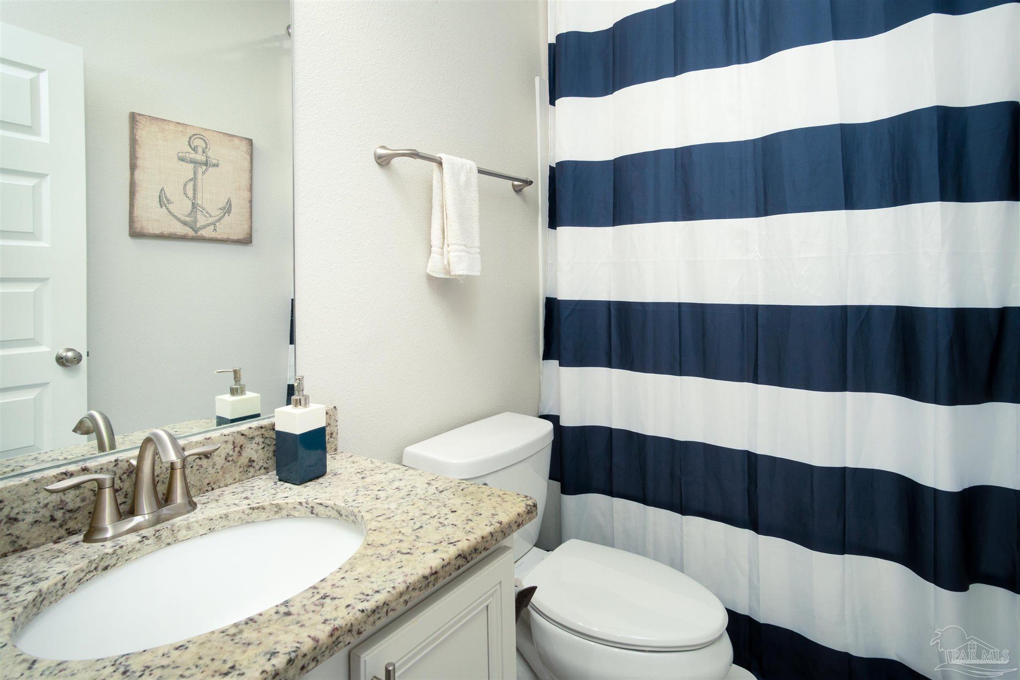 2759 Gemstone Circle Pace, FL 32571 - Photo 26 of 36 a bathroom with a sink a toilet and a mirror