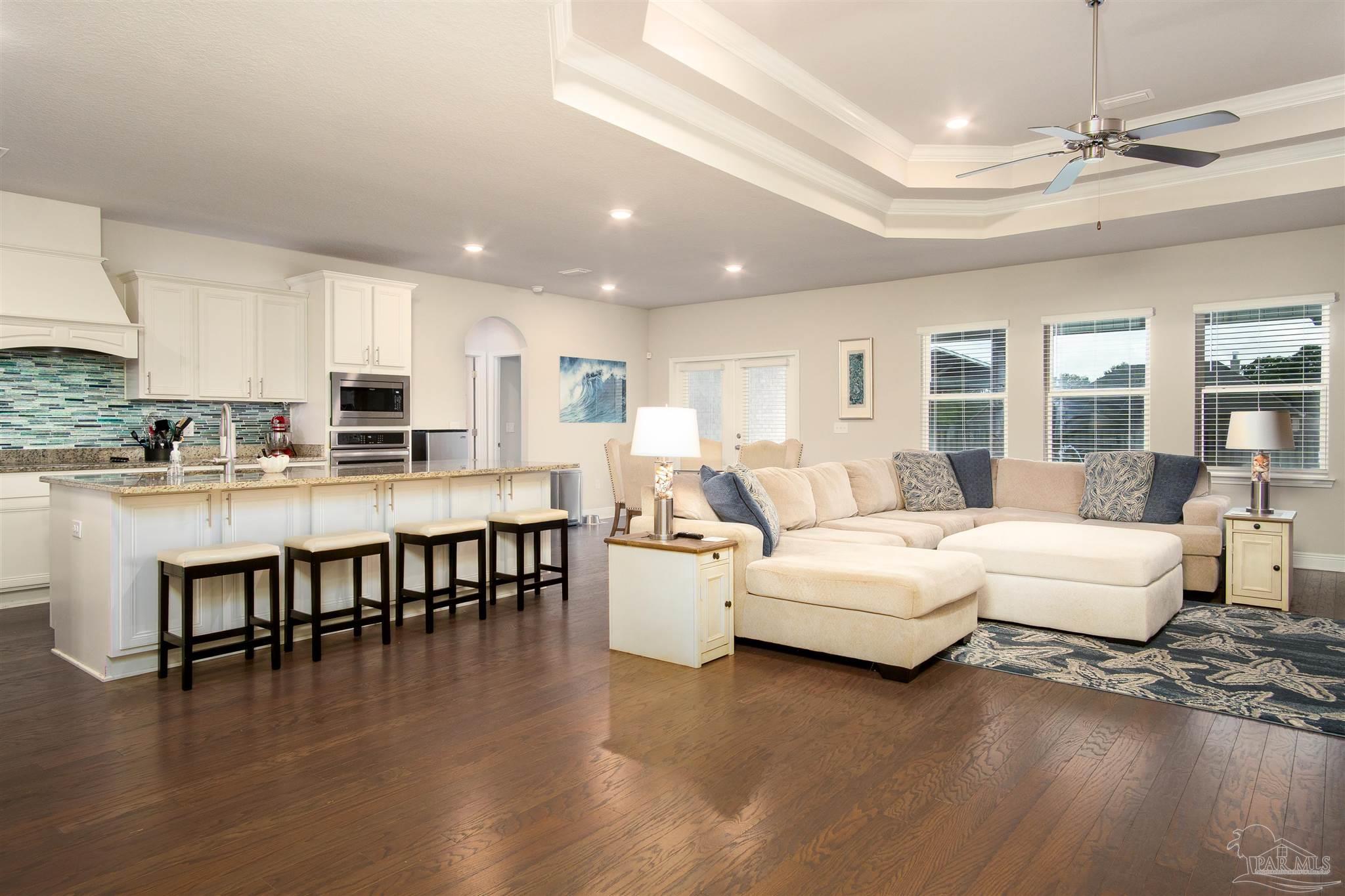 2759 Gemstone Circle Pace, FL 32571 - Photo 3 of 36 a living room with couches and kitchen view with wooden floor