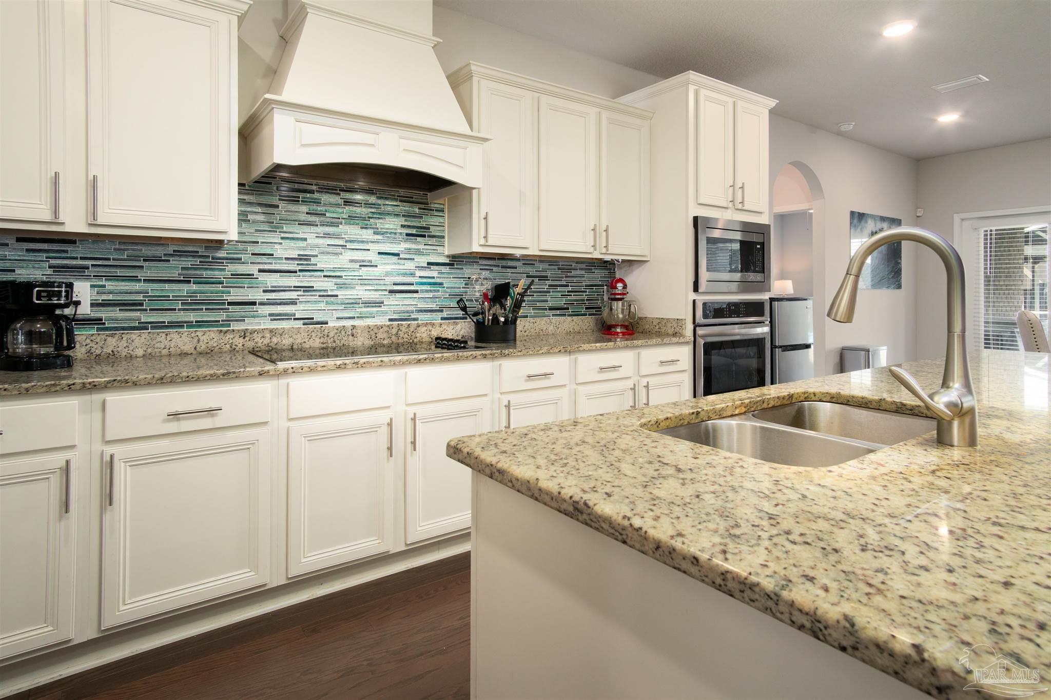 2759 Gemstone Circle Pace, FL 32571 - Photo 5 of 36 a kitchen with stainless steel appliances granite countertop a sink a stove and white cabinets