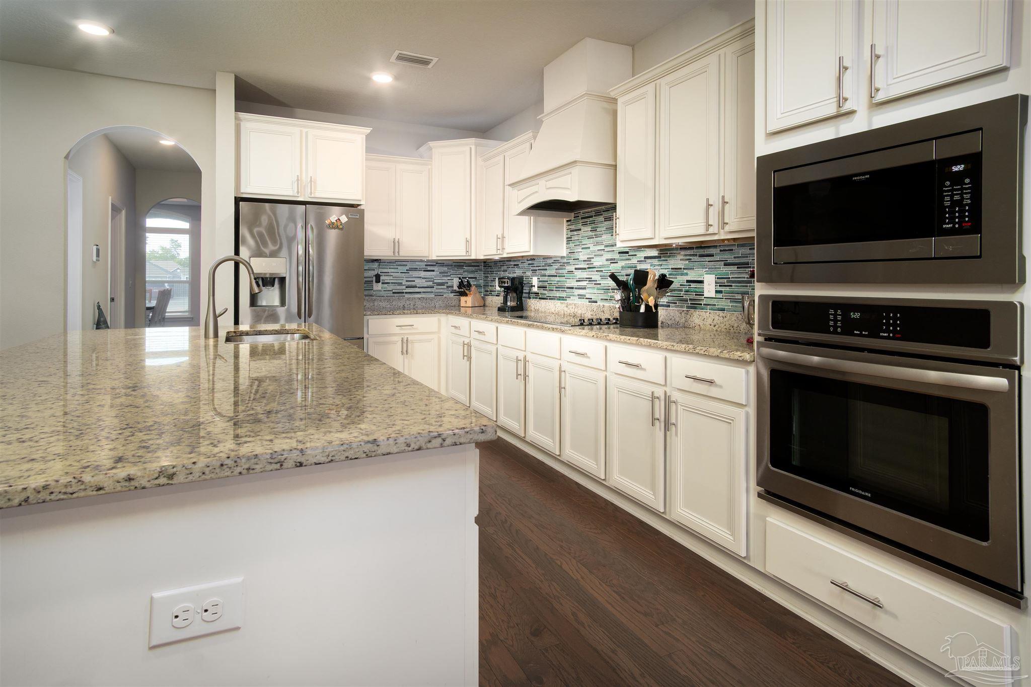 2759 Gemstone Circle Pace, FL 32571 - Photo 6 of 36 a kitchen with stainless steel appliances granite countertop a stove a sink and a microwave