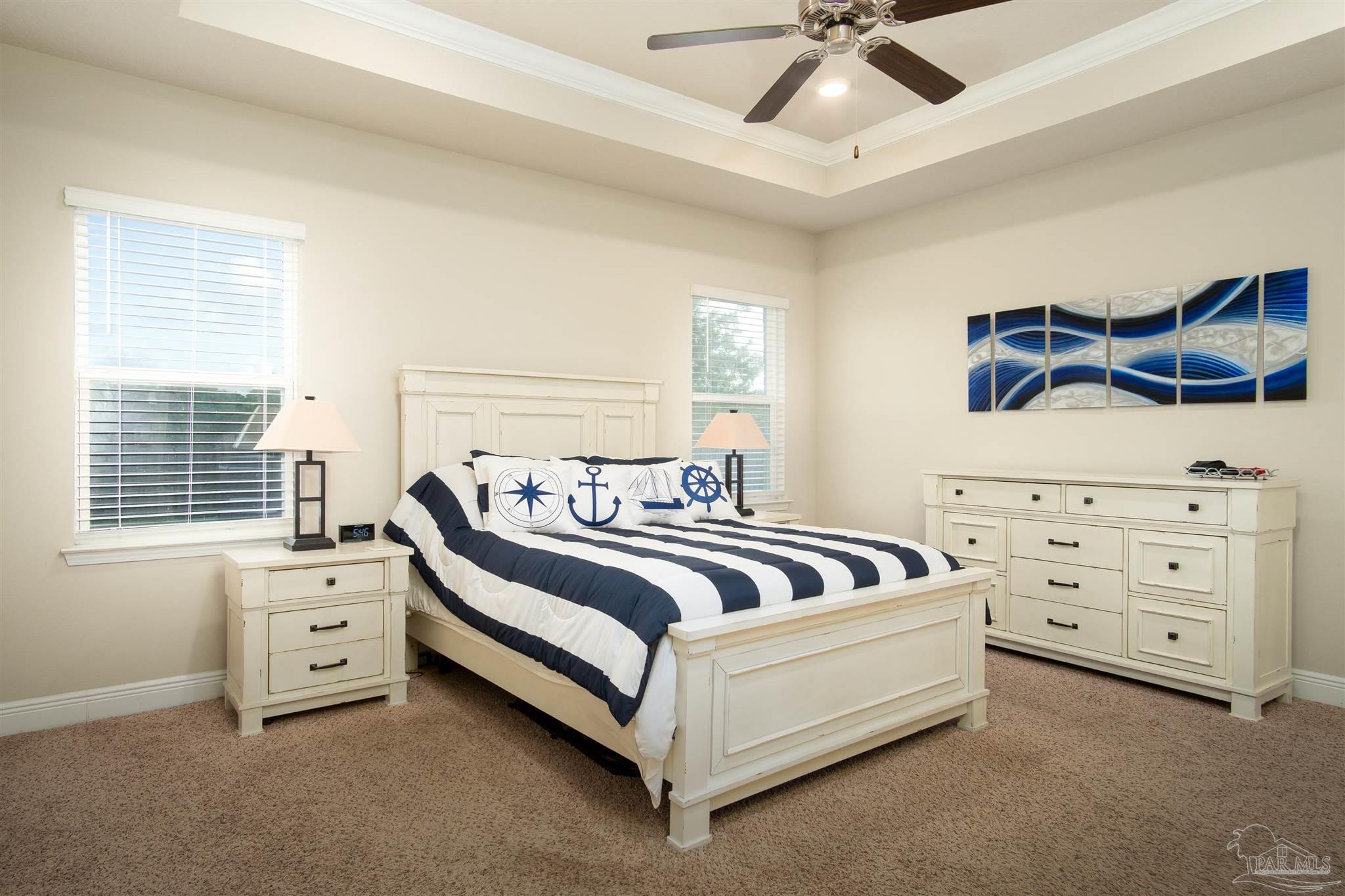 2759 Gemstone Circle Pace, FL 32571 - Photo 10 of 36 a spacious bedroom with a bed and a ceiling fan