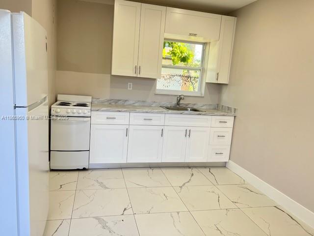 922 Northwest 2nd Street, Unit 4 Miami, FL 33128 - Photo 1 of 35 a kitchen with a sink a stove and white cabinets