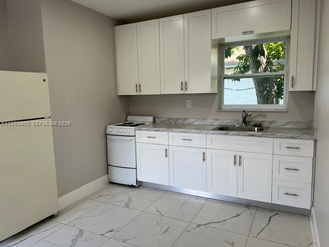 922 Northwest 2nd Street, Unit 4 Miami, FL 33128 - Photo 17 of 35 a kitchen with white cabinets and white appliances