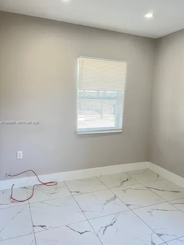 an empty room with a window and wooden floor