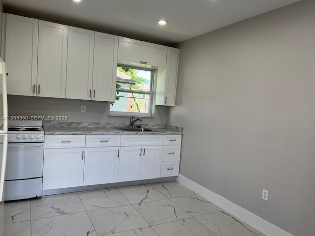 922 Northwest 2nd Street, Unit 4 Miami, FL 33128 - Photo 33 of 35 a kitchen with granite countertop white cabinets white appliances with a sink and dishwasher