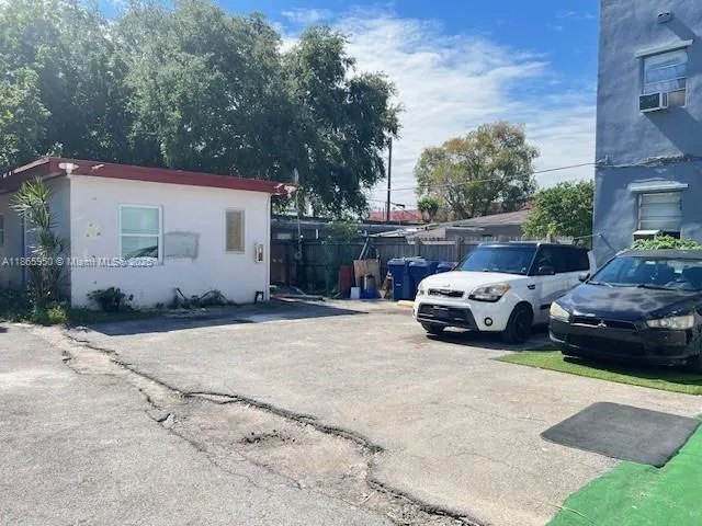 a white house covered with tall trees