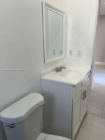 a bathroom with a sink vanity mirror and toilet
