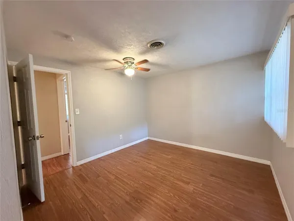 a view of an empty room with wooden floor