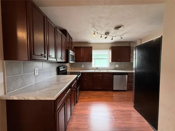 a kitchen with stainless steel appliances granite countertop a stove a sink and a microwave