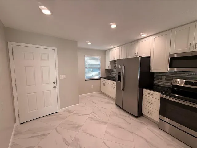 a kitchen with kitchen island a sink appliances and cabinets