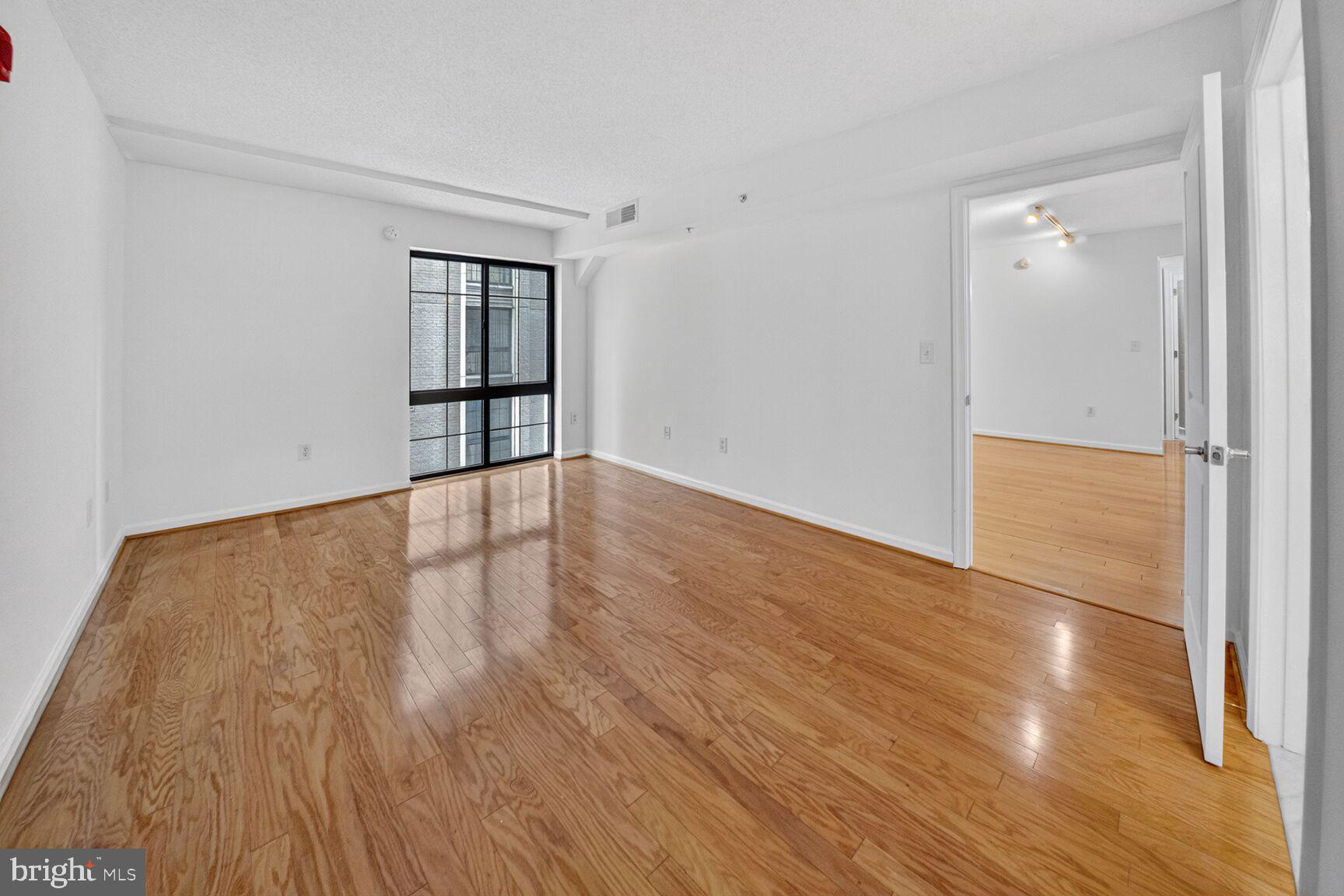 7923 Eastern Avenue Northwest, Unit 404 Silver Spring, MD 20910 - Photo 14 of 20 wooden floor in an empty room with a window