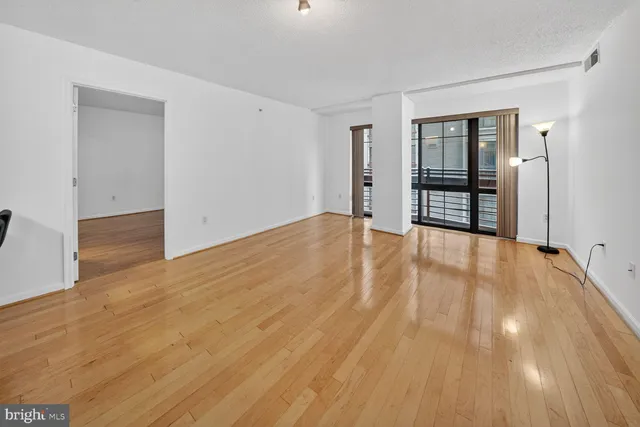a view of an empty room with wooden floor