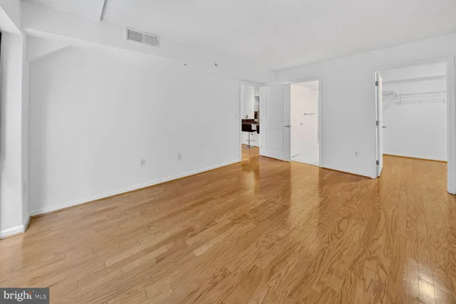 a view of empty room with wooden floor