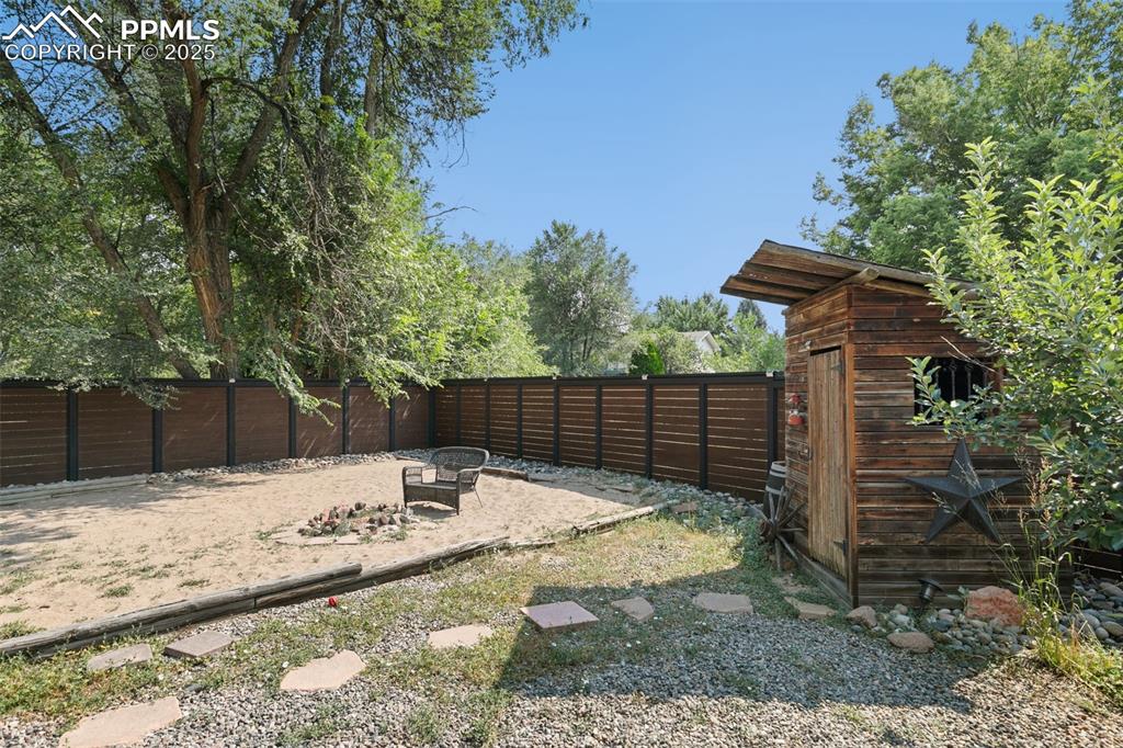 1921 Van Diest Road Colorado Springs, CO 80915 - Photo 42 of 45 Fenced backyard featuring a patio area, a shed, and a fire pit