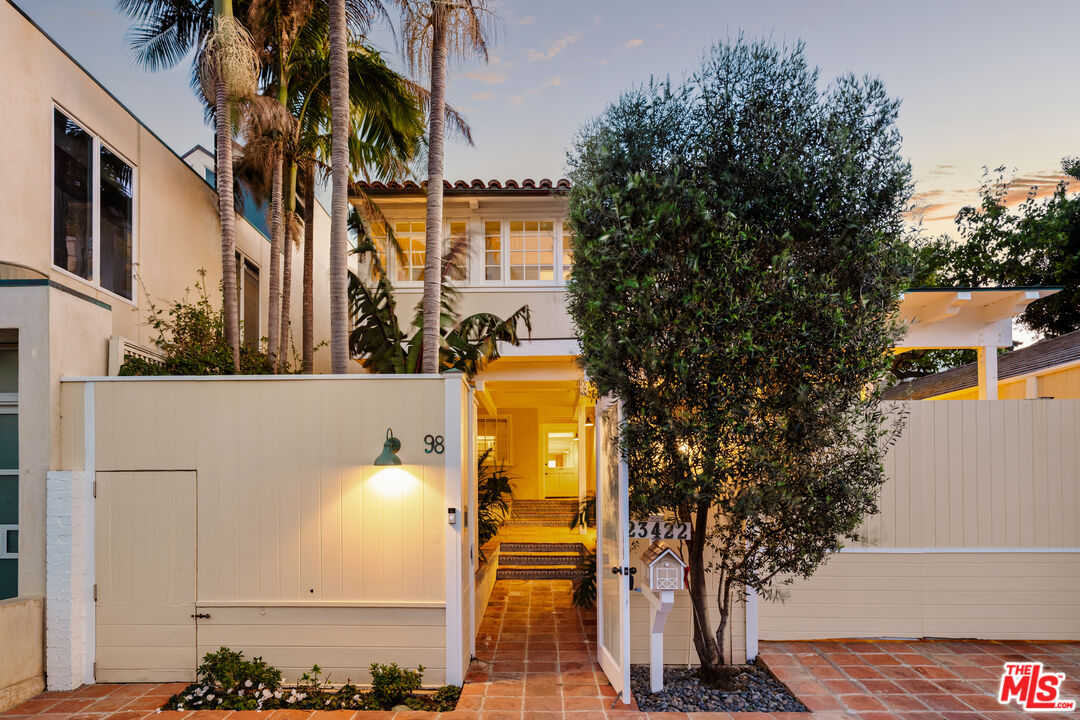 23422 Malibu Colony Road, Unit 98 Malibu, CA 90265 - Photo 42 of 42 a view of a white house with wooden fence and large trees