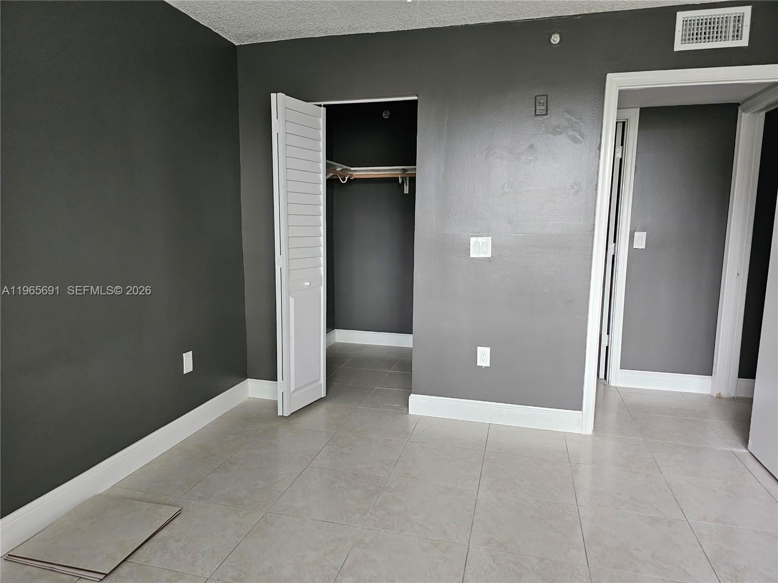2051 Renaissance Boulevard, Unit 104 Miramar, FL 33025 - Photo 21 of 39 wooden floor and cabinet in a hall with an empty shower