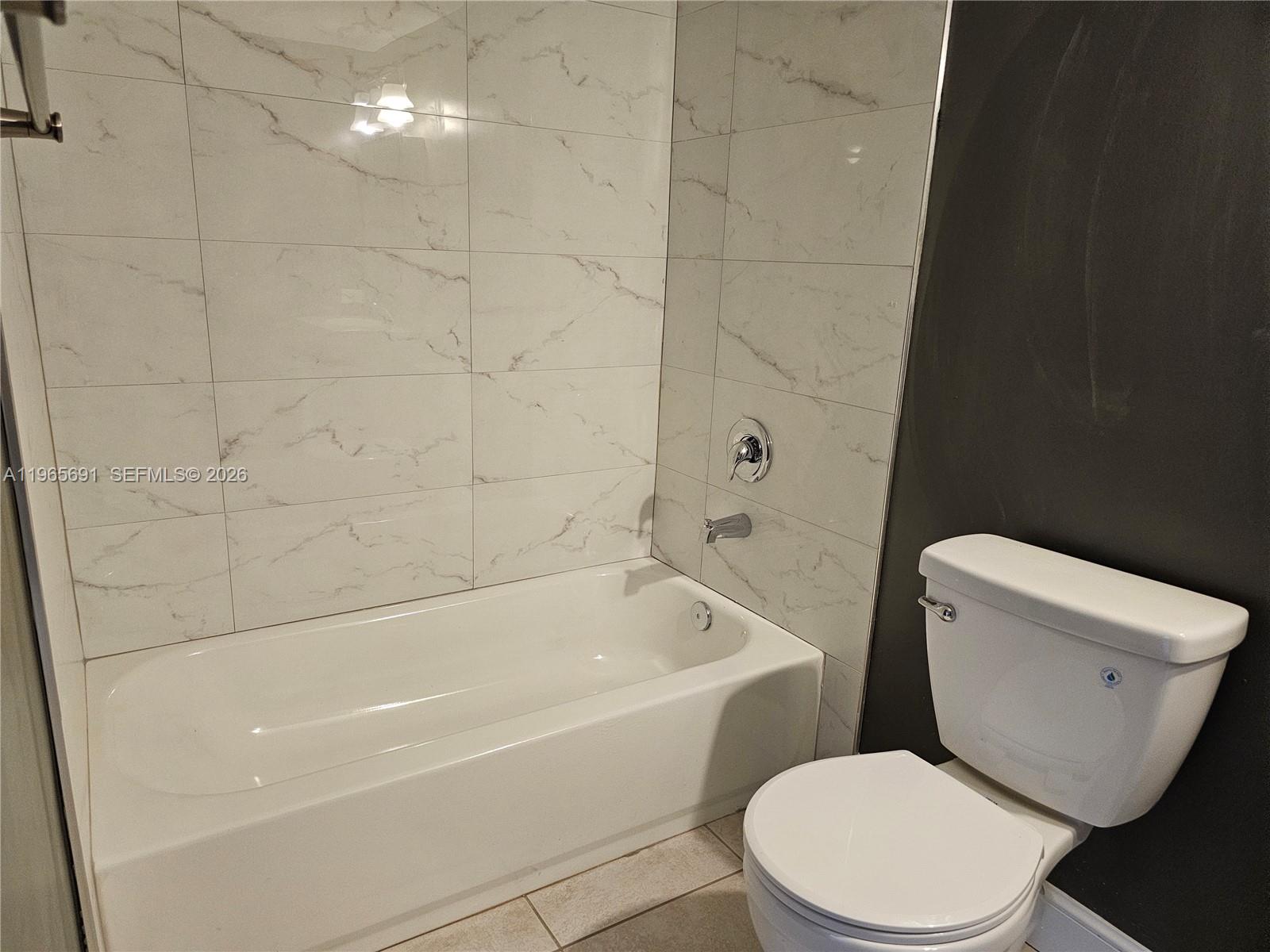 2051 Renaissance Boulevard, Unit 104 Miramar, FL 33025 - Photo 23 of 39 a white toilet and tub sitting next to a bathroom sink