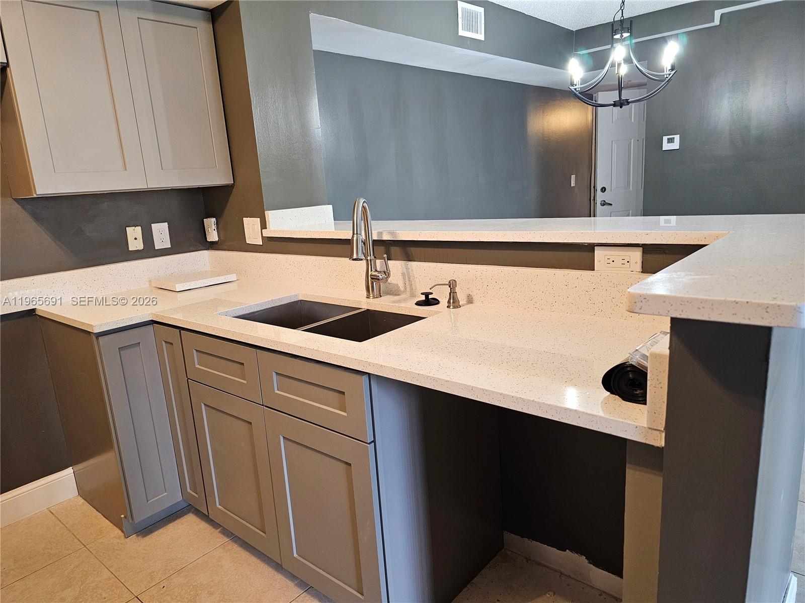 2051 Renaissance Boulevard, Unit 104 Miramar, FL 33025 - Photo 27 of 39 a kitchen with a sink and a mirror